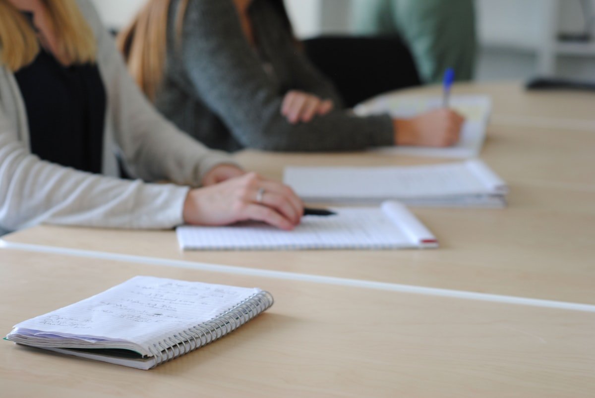 Candidate writing the German exam writing section on paper