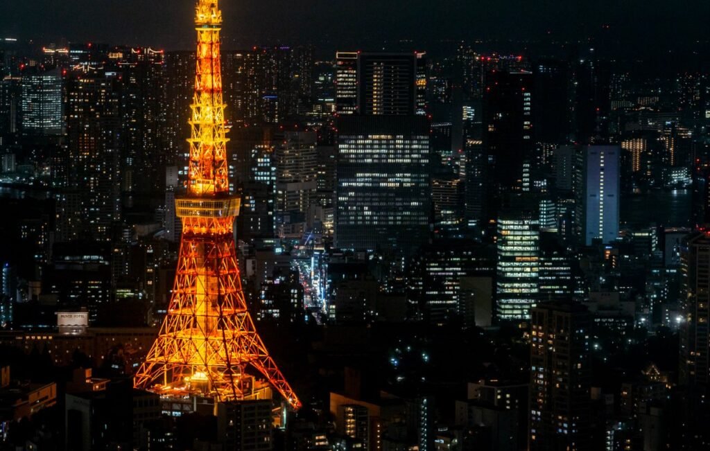 A stunning night view of Tokyo Tower glowing amidst the bustling cityscape of Tokyo.